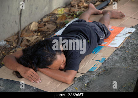 Uomo dorme sul marciapiede, Manila, Filippine. Foto Stock