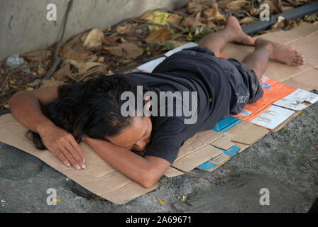 Uomo dorme sul marciapiede, Manila, Filippine. Foto Stock