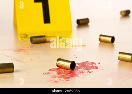 Crime Scene Investigation CSI prova marker con vuoto, sparò 9mm involucri punto sul sangue coperto con pavimento in legno di sfondo - polizia, prove o avanti Foto Stock