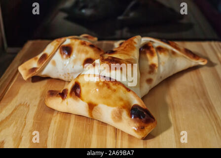Sfiha, tipo di torta come originari della Siria e del Libano e largamente consumata in tutto il mondo, su tavola in legno rustico. Foto Stock