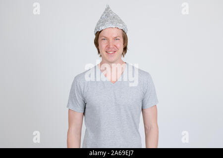 Giovane uomo che indossa la lamina di tin hat come teoria della cospirazione concept Foto Stock