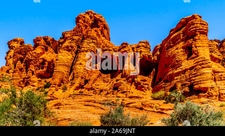 Il rosso irregolare Aztec formazione di arenaria vicino al Arch Rock campeggio sotto il cielo blu chiaro in il Parco della Valle di Fire State in Nevada, STATI UNITI D'AMERICA Foto Stock