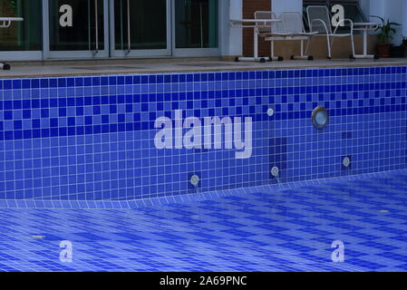 Primo piano acqua che scorre rapidamente dal tubo di sbocco nel vuoto la piscina dopo la ristrutturazione e la pulizia, in pieno il concetto di flusso, metafora Foto Stock