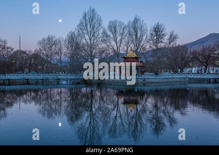 Un predawn immagine del calare della luna su una piccola pagoda dal lago in Piazza Potala a Lhasa, in Tibet. Foto Stock