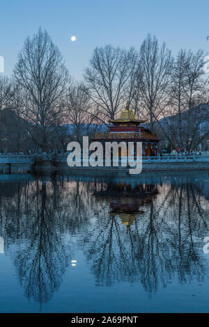 Un predawn immagine del calare della luna su una piccola pagoda dal lago in Piazza Potala a Lhasa, in Tibet. Foto Stock