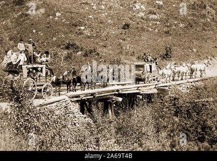 Due stagecoaches attraversando un ponte; gli uomini in carri sono di ondulazione o il ribaltamento di loro cappelli per il fotografo. Foto Stock