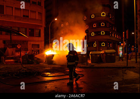 Barcellona, Spagna - 19 ottobre 2019: un vigile del fuoco di notte con il fuoco in background, lavorando in una pericolosa situtation durante il catalano sommosse con po Foto Stock