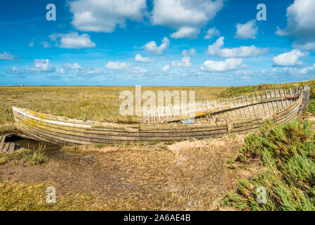 Rustico vecchia barca lasciata decadere sulle barene tra Blakeney e Cley accanto il mare villaggi costieri sulla costa del Norfolk del nord est dell'Inghilterra, Regno Unito. Foto Stock