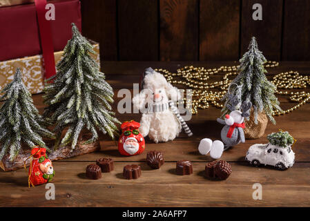 Assortimento di raffinati cioccolatini, bianco, scuro e cioccolato al latte dolci sfondo. Interni di natale con confezioni regalo e incendi di Natale Foto Stock