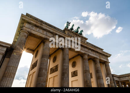 Basso angolo vista della Porta di Brandeburgo a Berlino in serata, sun flare su sfondo. Germania Foto Stock