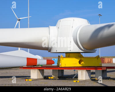 Giant di rotori di turbine eoliche nel mulino a vento cantiere per la costruzione di parchi eolici in mare, sotto il cielo blu chiaro Foto Stock