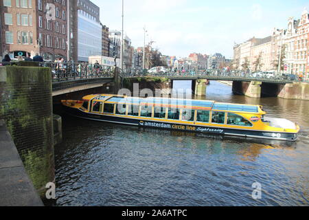 Tour in barca passando sotto un ponte sul canale di Amsterdam Foto Stock