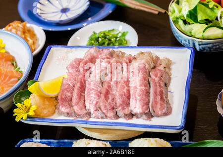 Tagliate a fette grigliate di striscia rare lombo di grado di maturazione bistecca di manzo servita con sale e calce. Foto Stock