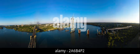 Antenna vista Panorama di Incomplete Automobile Bridge e il ponte di Arco sullo sfondo della città industriale. Foto Stock