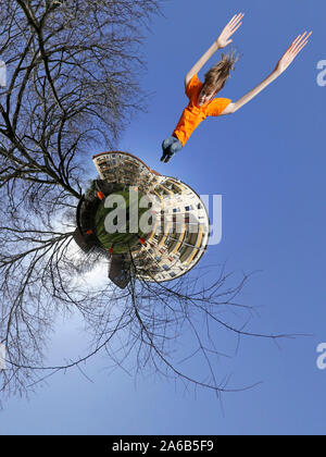 Un piccolo pianeta foto di un blocco di case e un ragazzo jumping, Wilhelmsburg, Amburgo, Germania. Foto Stock