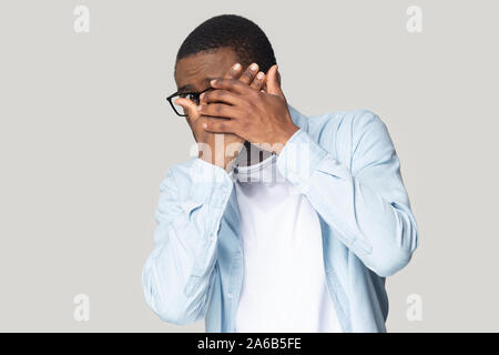 Colpo alla testa spaventati African American uomo nascondersi dietro le mani Foto Stock