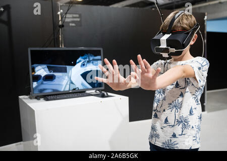 BRATISLAVA, Slovacchia - Oct 25, 2019: Giovane ragazzo ad esplorare la simulazione al computer utilizzando la realtà virtuale bicchieri al Mall a Bratislava, in Slovacchia Foto Stock