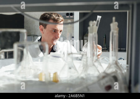 Scienziati del Laboratorio di analisi mediche conduce esperimenti di chimica con liquidi Foto Stock