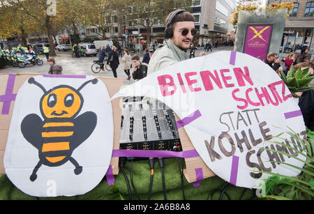 Hannover, Germania. 25 ott 2019. Un dimostratore si trova di fronte a una console di mixaggio accanto a segni dicendo 'bee protezione invece di carbone inquinamento" durante un venerdì-per-futuro dimostrazione. Credito: Julian Stratenschulte/dpa/Alamy Live News Foto Stock