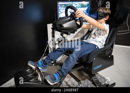 BRATISLAVA, Slovacchia - Oct 25, 2019: Giovane ragazzo plica gioco di corse su 2DOF simulatore di movimento con occhiali per realtà virtuale presso il centro commerciale di Bratislava, Slo Foto Stock