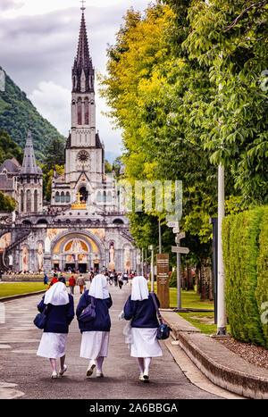 LOURDES - Giugno 15, 2019: vista delle monache sul fondo di Notre Dame du Rosaire basilica a Lourdes, Francia Foto Stock