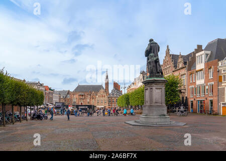 Haarlem/Olanda - 06 Ottobre 2019: la gente a piedi e in bicicletta nel centro città con la schiena, vista posteriore della statua di Laurens Janszoon Coster Foto Stock