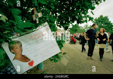 Fiori e persone in lutto al di fuori Kensington Palace nei giorni seguenti il funerale della principessa Diana, a Londra, Inghilterra, settembre 1997. Foto Stock