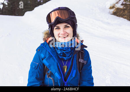 Sfondo di sport. Ritratto ragazza positiva snowboarder su una pendenza. Lo stile di vita di viaggio avventura invernale concetto, vacanze attività outdoor in vacanza. Foto Stock