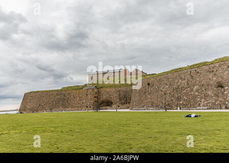 La fortezza di Varberg è un antica fortificazione costruita nel 1287-1300. un ragazzo e una ragazza sono in appoggio sul prato davanti alle mura, Varberg, Seweden Foto Stock