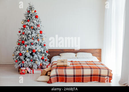 Albero di natale in camera da letto con letto matrimoniale e di doni vacanza anno nuovo Foto Stock