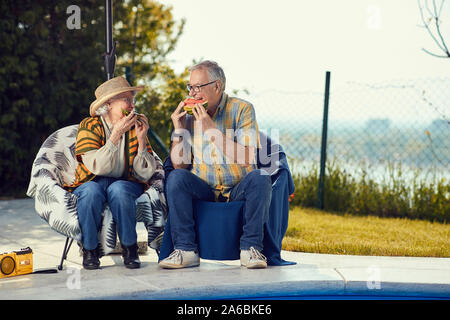 Coppia sorridente amici divertendosi insieme e mangiare anguria Foto Stock