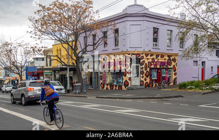 Ciclista ciclismo e traffico lungo Gertrude Street Fitzroy Melbourne Victoria Australia. Foto Stock