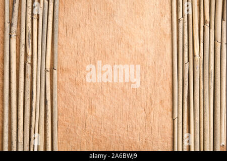 Canne secche in una fila sullo sfondo di legno. Foto Stock