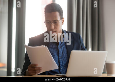 Grave nero manager accordo di lettura in ufficio Foto Stock