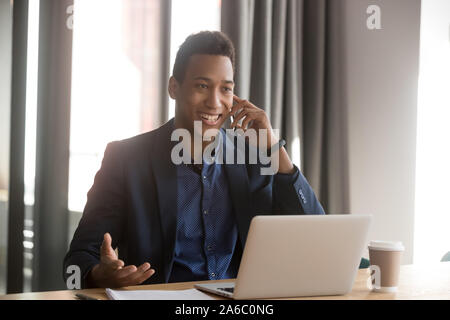 Sorridenti americano africano dipendente che effettua chiamata al client Foto Stock