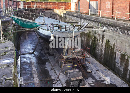 Yacht in legno in un Gloucester bacino asciutto essendo riparato Foto Stock