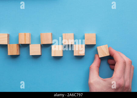 Lato la scelta di un blocco di legno da un set. Scelta aziendale concept Foto Stock