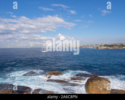 Barca Off La rocciosa costa Bondi a Sydney Foto Stock