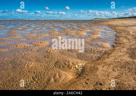 Modelli realizzati da piscine di acqua maree con bassa marea sulla spiaggia di Burnham Overy Staithe sulla baia di Holkham, costa del Norfolk del Nord, East Anglia, Inghilterra, Regno Unito. Foto Stock