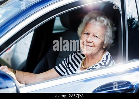 Senior donna alla guida di un'auto. Foto Stock