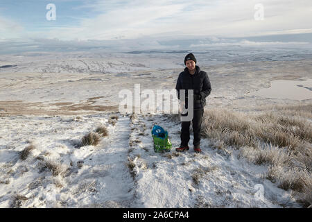 Walker su Whernside tappezzate in neve e ghiaccio metà inverno Yorkshire Dales Foto Stock