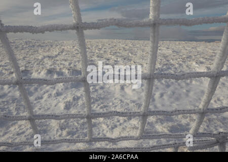 Recinto di filo ricoperto di trasformata per forte gradiente di brina sui Whernside tappezzate in neve e ghiaccio metà inverno Yorkshire Dales Foto Stock