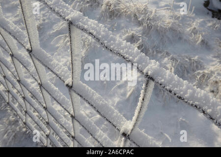 Recinto di filo ricoperto di trasformata per forte gradiente di brina sui Whernside tappezzate in neve e ghiaccio metà inverno Yorkshire Dales Foto Stock