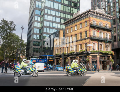 L'Albert public house con la polizia sulla moto passando sulla strada in Westminster, Londra, Regno Unito Foto Stock