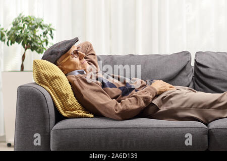 Uomo anziano di dormire su un divano a casa Foto Stock