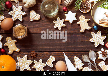 Rendendo pan di zenzero i biscotti con ingredienti su sfondo di legno Foto Stock