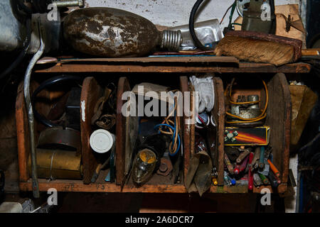 Vecchio scaffale di legno sulla parete con vecchi strumenti Foto Stock
