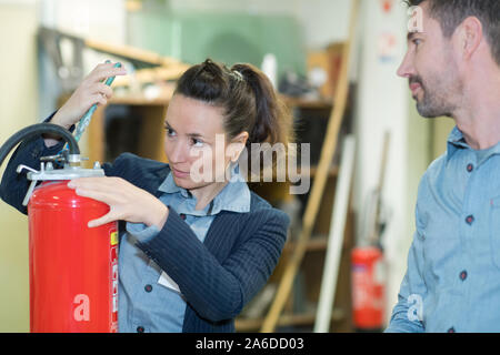 Controllare gli estintori in magazzino Foto Stock