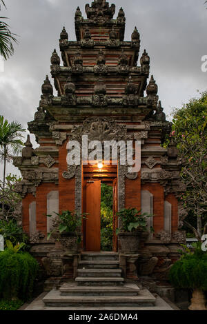 Gli ornati porte scolpite e l'ingresso nella cultura tempio indù di Bali di notte Foto Stock