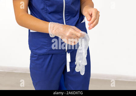 Il medico indossa dei guanti di protezione in lattice Foto Stock